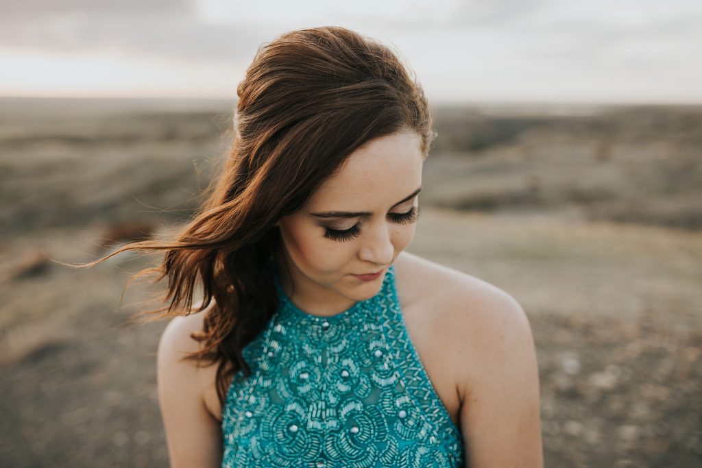 closeup of grad girl senior looking down hair blowing softly
