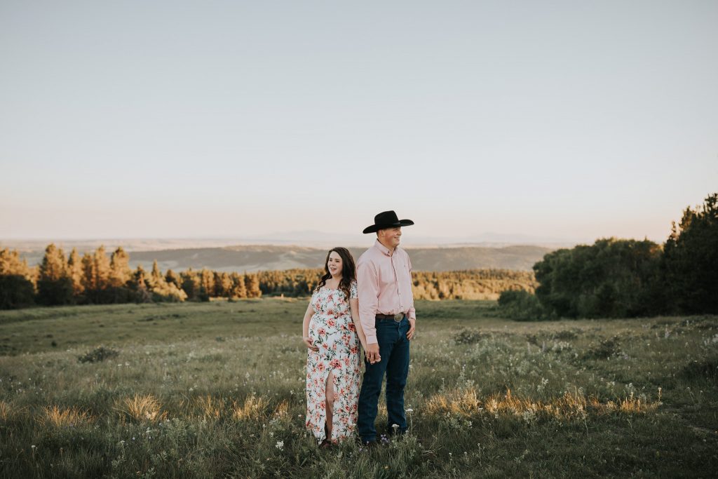 expecting couple holding hands back to back head of the mountain cypress hills alberta maternity